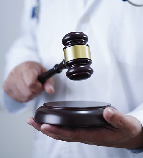 Médico asiático segurando martelo do tribunal - mariano-santana copiar